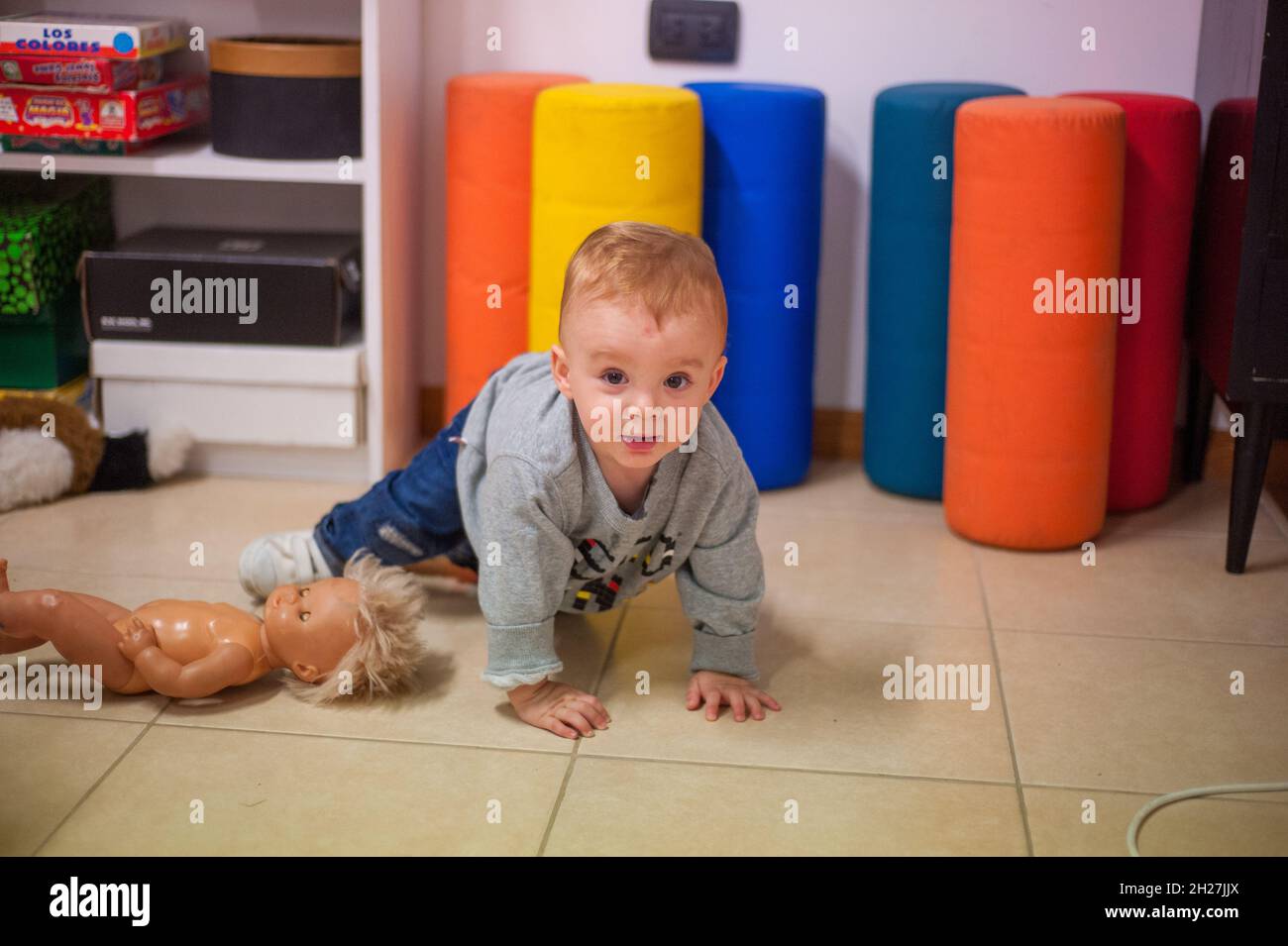 Nettes kleines kaukasisches Kind im Haus, das auf dem Boden spielt. Stockfoto