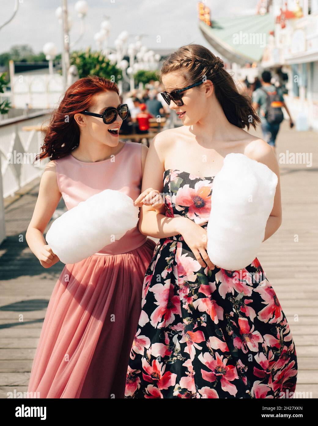 Nahaufnahme Porträt von lächelnden aufgeregt Mädchen mit Sonnenbrillen und  Abschlussball Kleider halten Zuckerwatte im Vergnügungspark. Jugendliche in  rosa Abendkleider Stockfotografie - Alamy