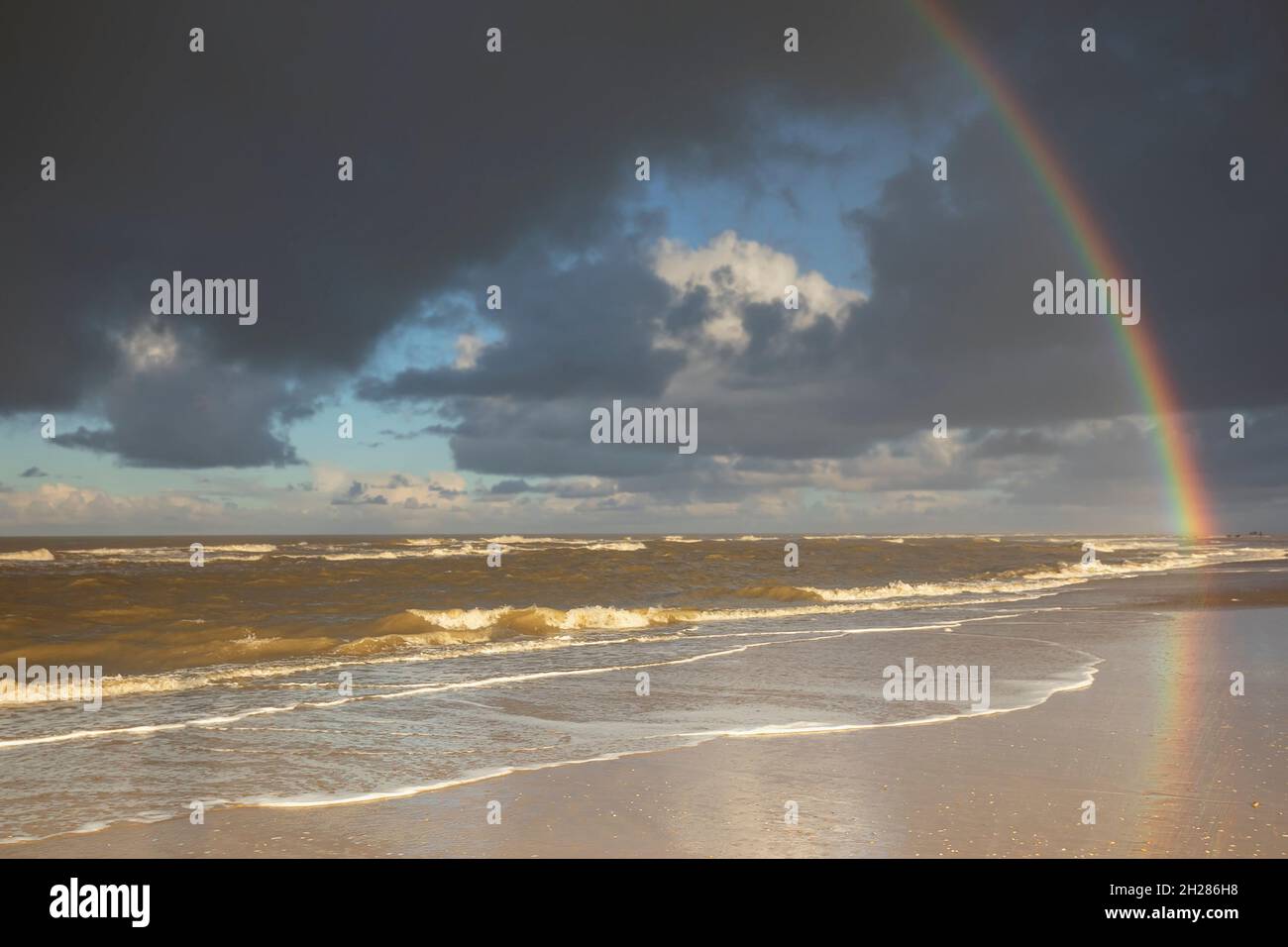 regenbogen über Nordseestrand im Regen, Holland Stockfoto