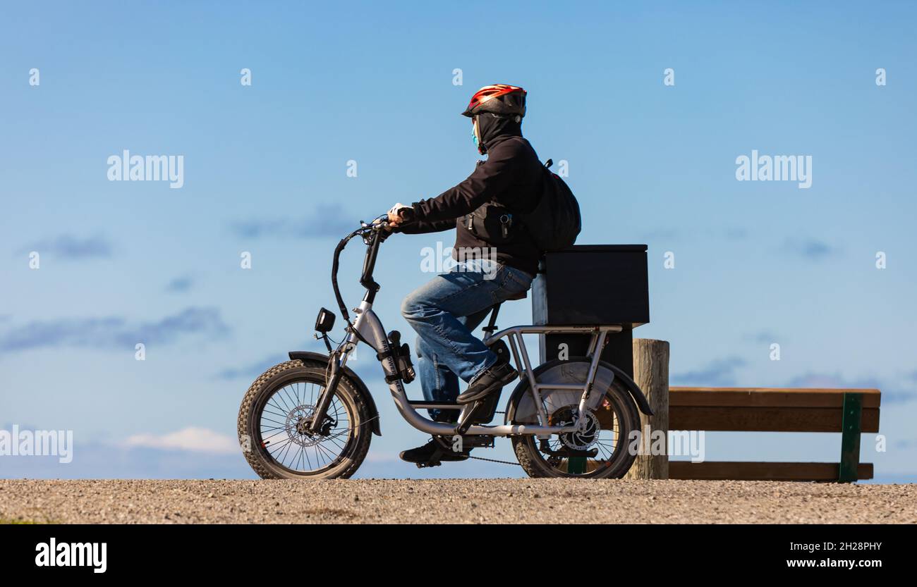 Mann auf einem Mountainbike mit dicken Reifen und Helm in einem Park. Fat Bike. Stockfoto