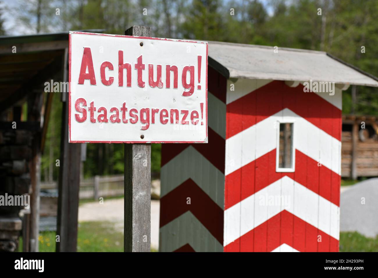 Tafel 'Staatsgrenze' im Freilichtmuseum mit alten Bauernhäusern und Gebäuden in Großgmain in Salzburg, Österreich, Europa - Schild 'State border' im Stockfoto