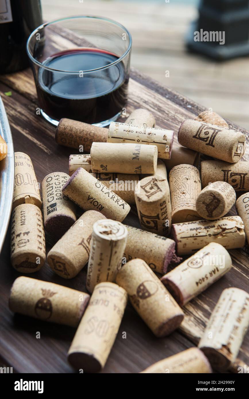 Weinglas umgeben von Flaschenkorken Stockfoto