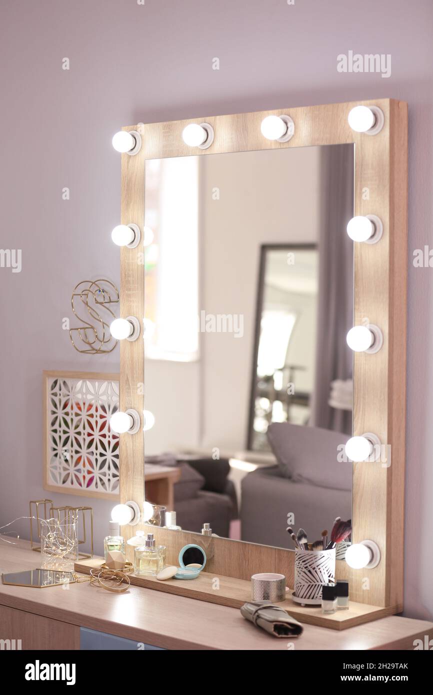 Spiegel mit Glühbirnen und Kosmetikprodukten auf dem Frisiertisch im  Innenbereich Stockfotografie - Alamy