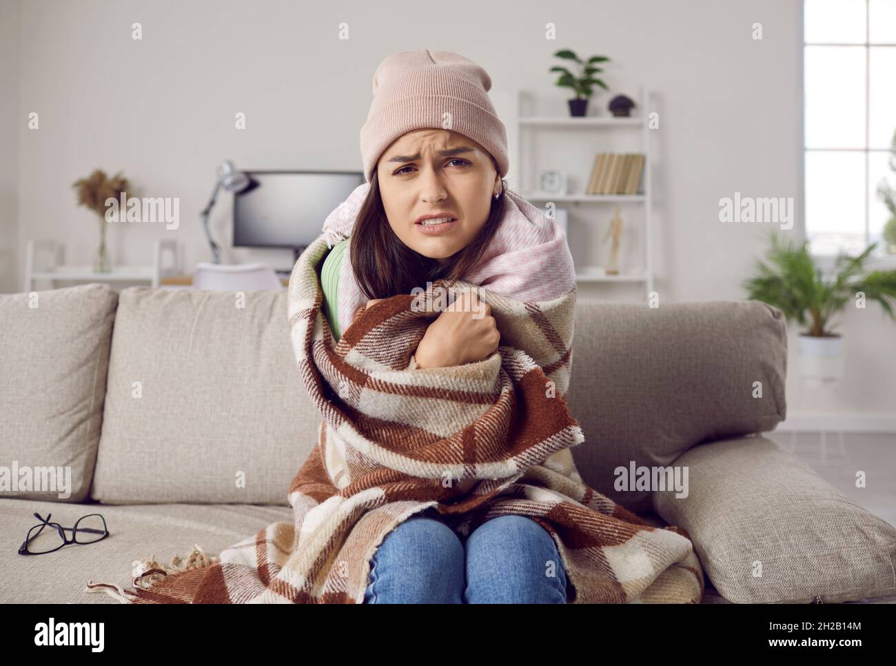 Die junge Frau friert im Winter in ihrem Haus, weil sie Probleme mit der Zentralheizung hatte Stockfoto
