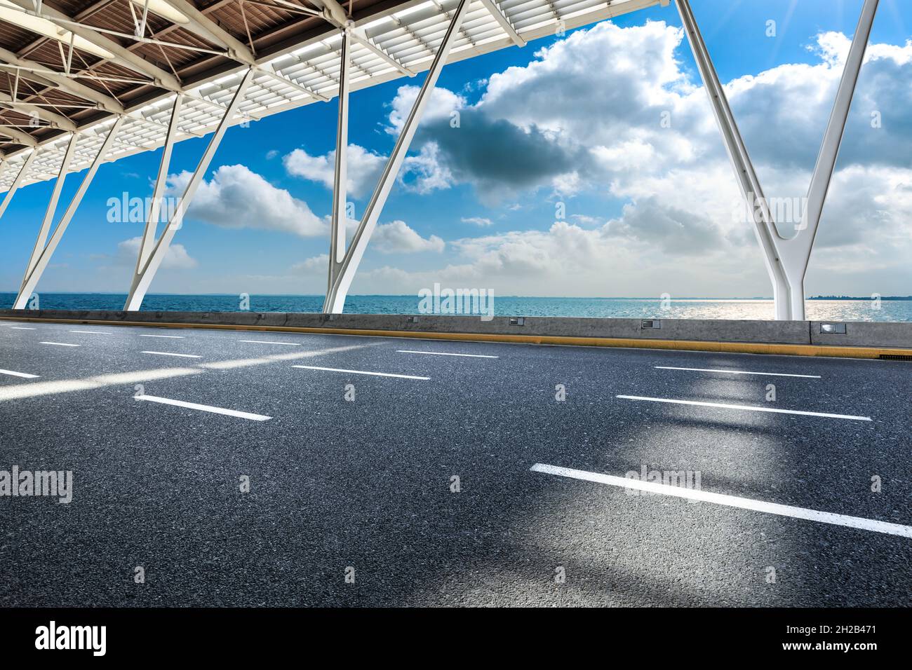 Asphaltstraße und Seenlandschaft an einem sonnigen Tag. Stockfoto