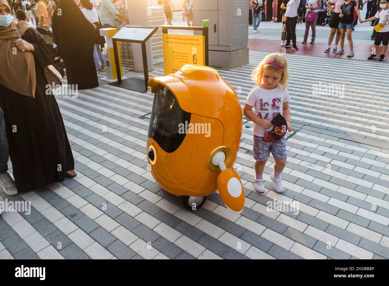 Dubai, VAE - 10.15.2021 Aufnahme eines kleinen Mädchens, das mit einem niedlichen kleinen Roboter an der EXPO 2020 spielt. Ereignis Stockfoto