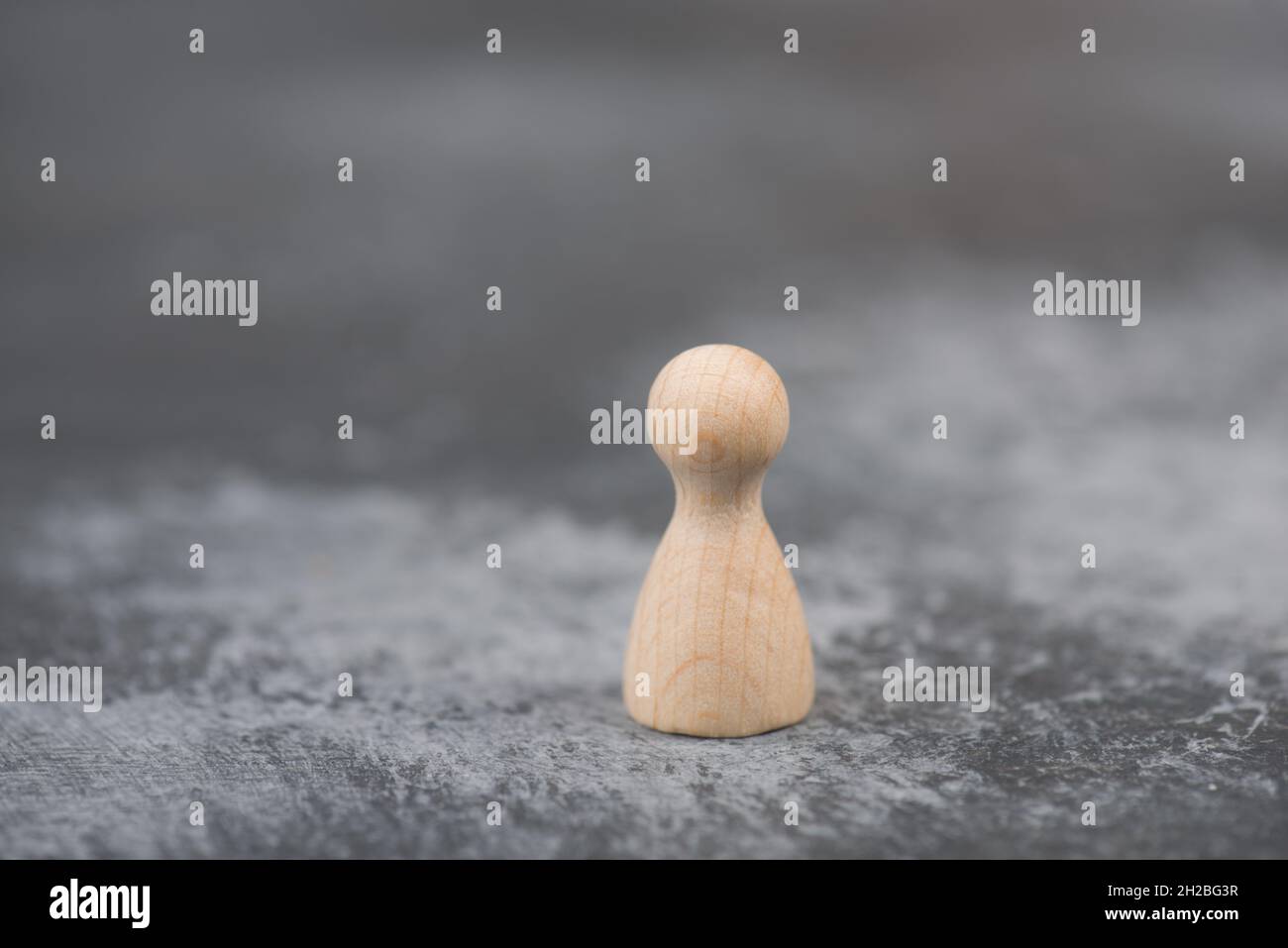 Person steht allein, getrennt von der Gruppe, Symbol Einsamheit, dunkler Hintergrund Stockfoto