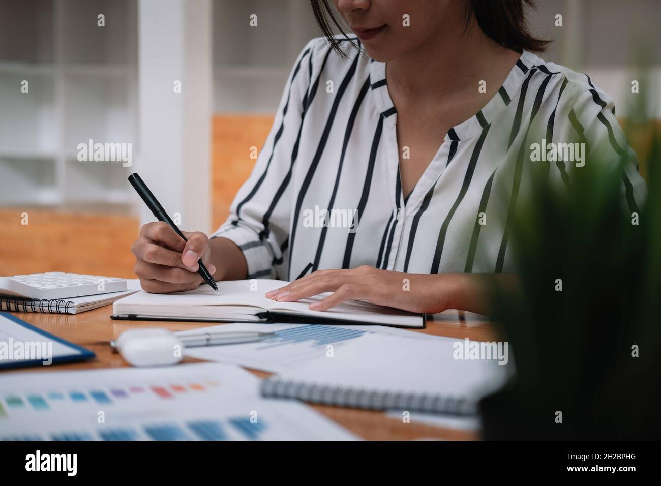 Nahaufnahme von Geschäftsmann oder Buchhalter Hand halten Stift arbeiten auf Rechner und Laptop-Computer, um Geschäftsdaten zu berechnen während notieren bei Stockfoto