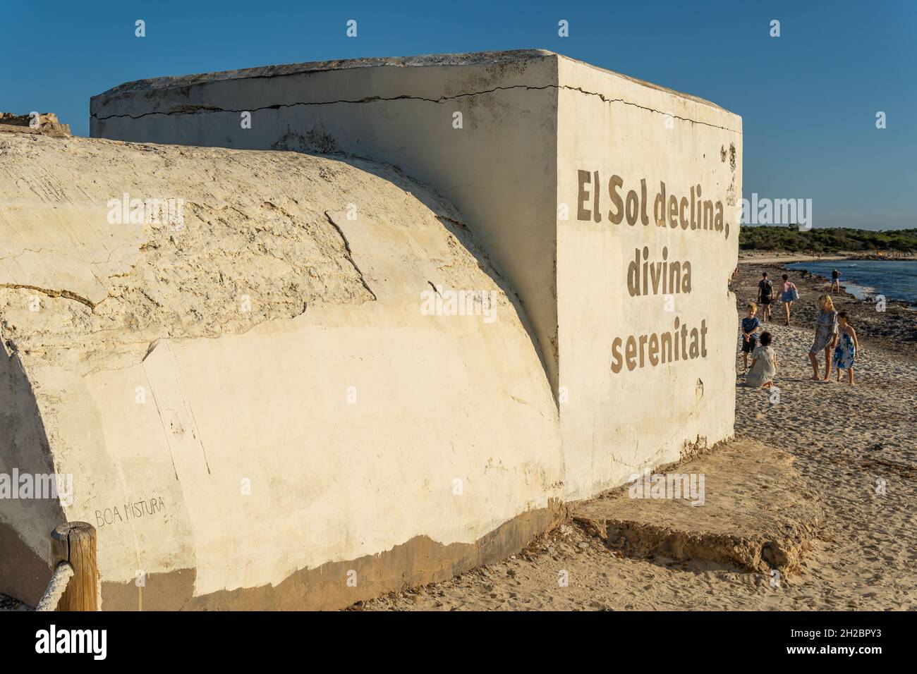 Es Trenc, Spanien; 11 2021. oktober: Alter Bunker des spanischen Bürgerkrieges am Strand von Es Trenc, neben Badegästen, bei Sonnenuntergang. Insel Mallorca, Spanien Stockfoto