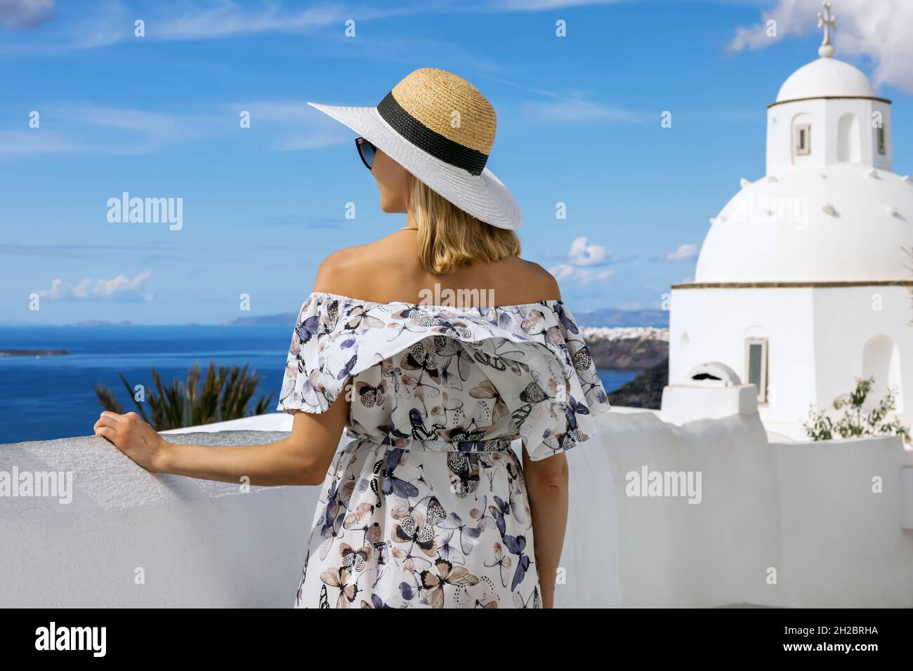 Frau mit Strohhut und Kleid im Sommerurlaub auf Santorini. Griechenland Stockfoto