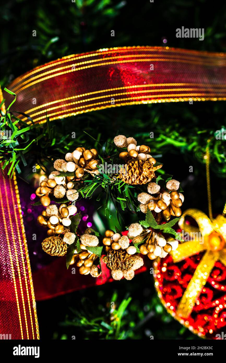 Vertikale Nahaufnahme eines Kranzes und Dekorationen, die an einem Weihnachtsbaum hängen Stockfoto
