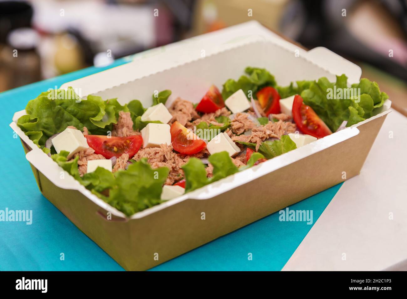 Gemüsesalat mit Thunfisch und Feta-Käse und Kirschtomaten, verpackt in einer cortonplatte zur Lieferung. Stockfoto