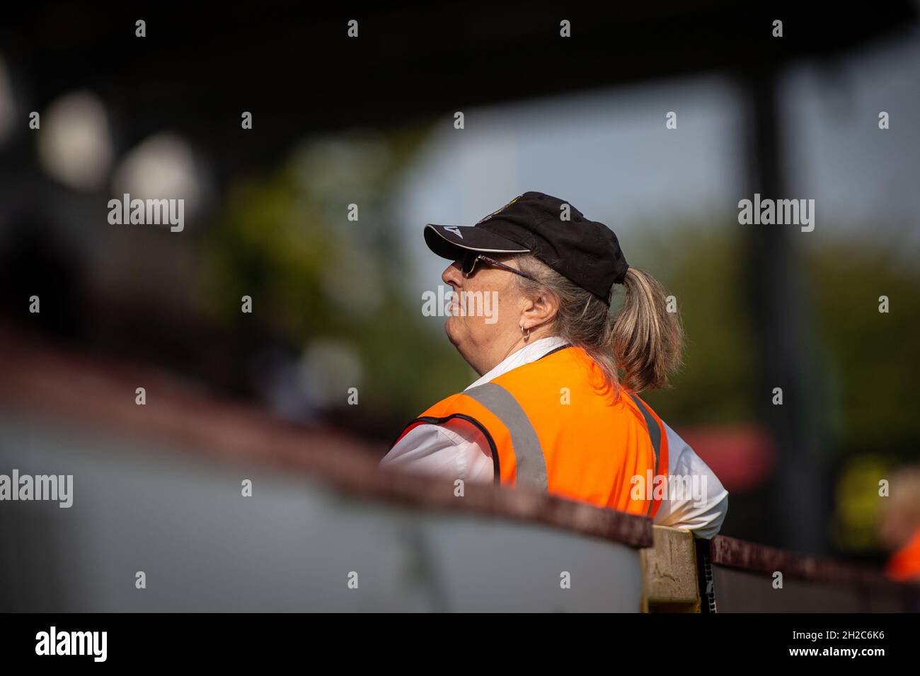 Weibliche Stewardin trägt eine Jacke und arbeitet bei einem Fußballspiel in England Stockfoto