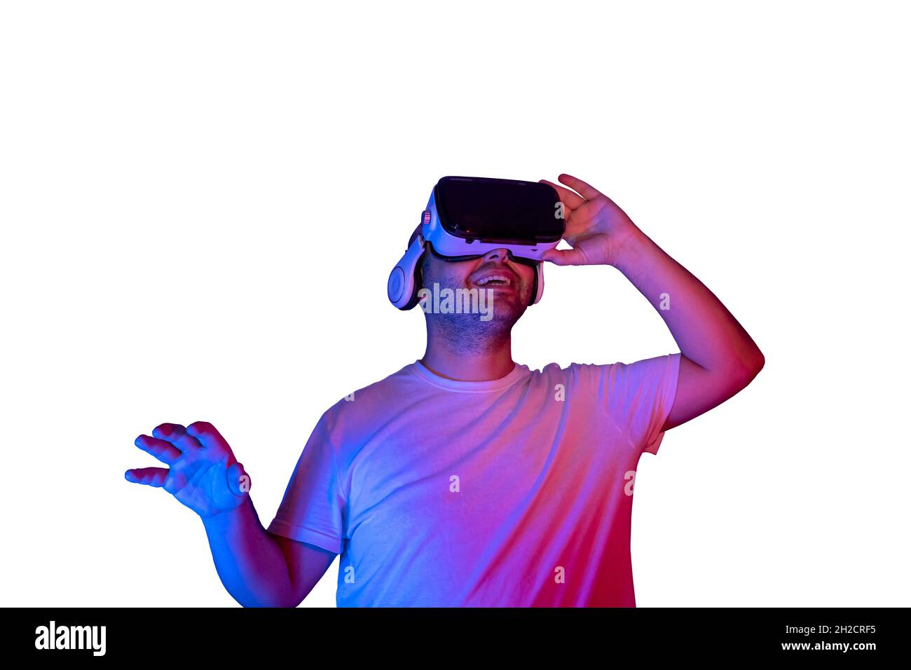 Junger Mann mit Virtual-Reality-Brille isoliert immer glücklich. Stockfoto