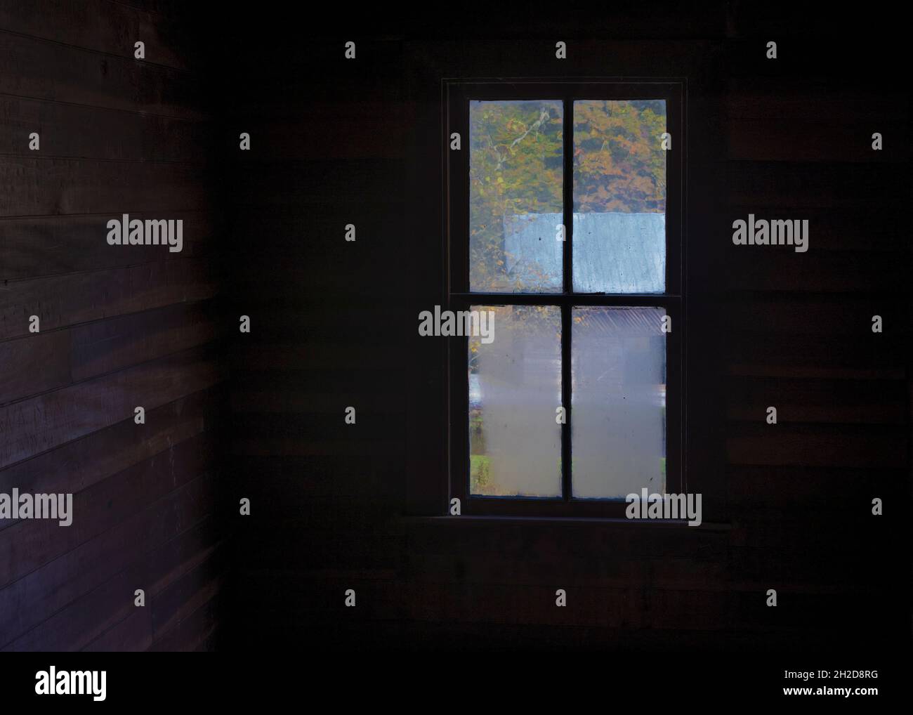 Blick durch ein altes Fenster in ein leeres altes Haus im Smoky Mountain National Park. Stockfoto