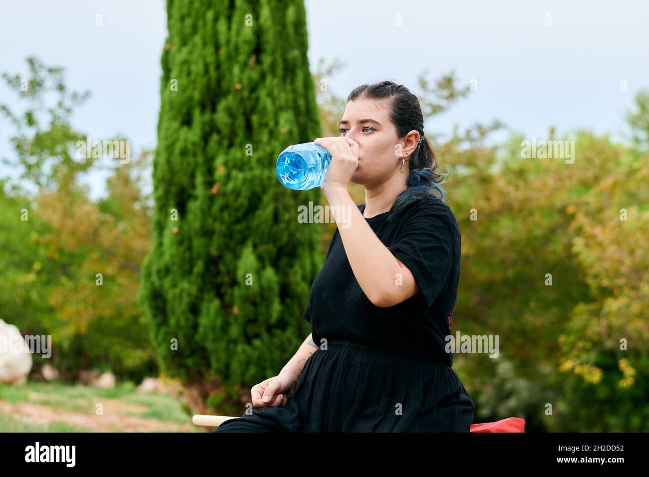 Frau trinkt nach dem Kung Fu Training in einem Park Wasser Stockfoto