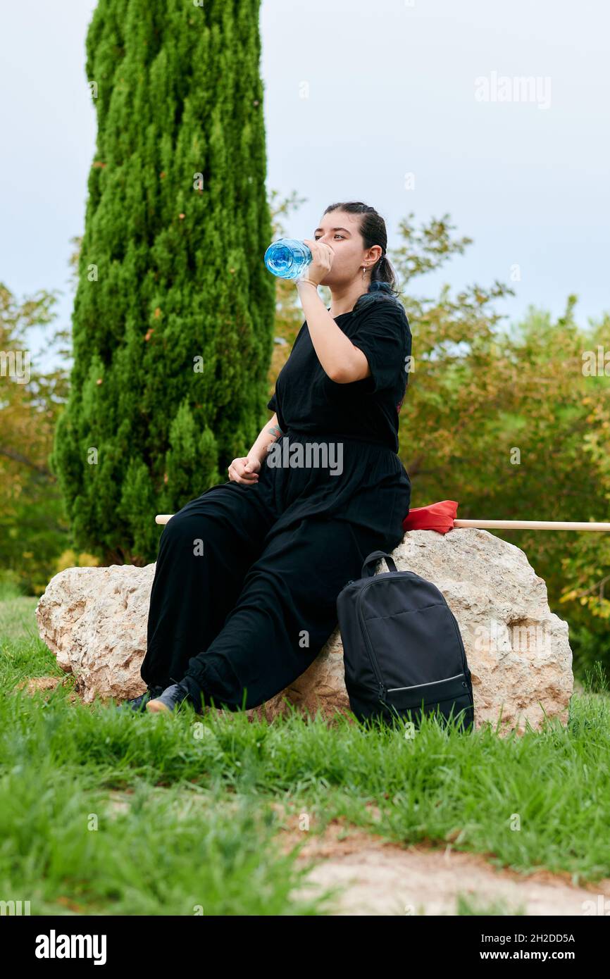 Frau trinkt nach dem Kung Fu Training in einem Park Wasser Stockfoto