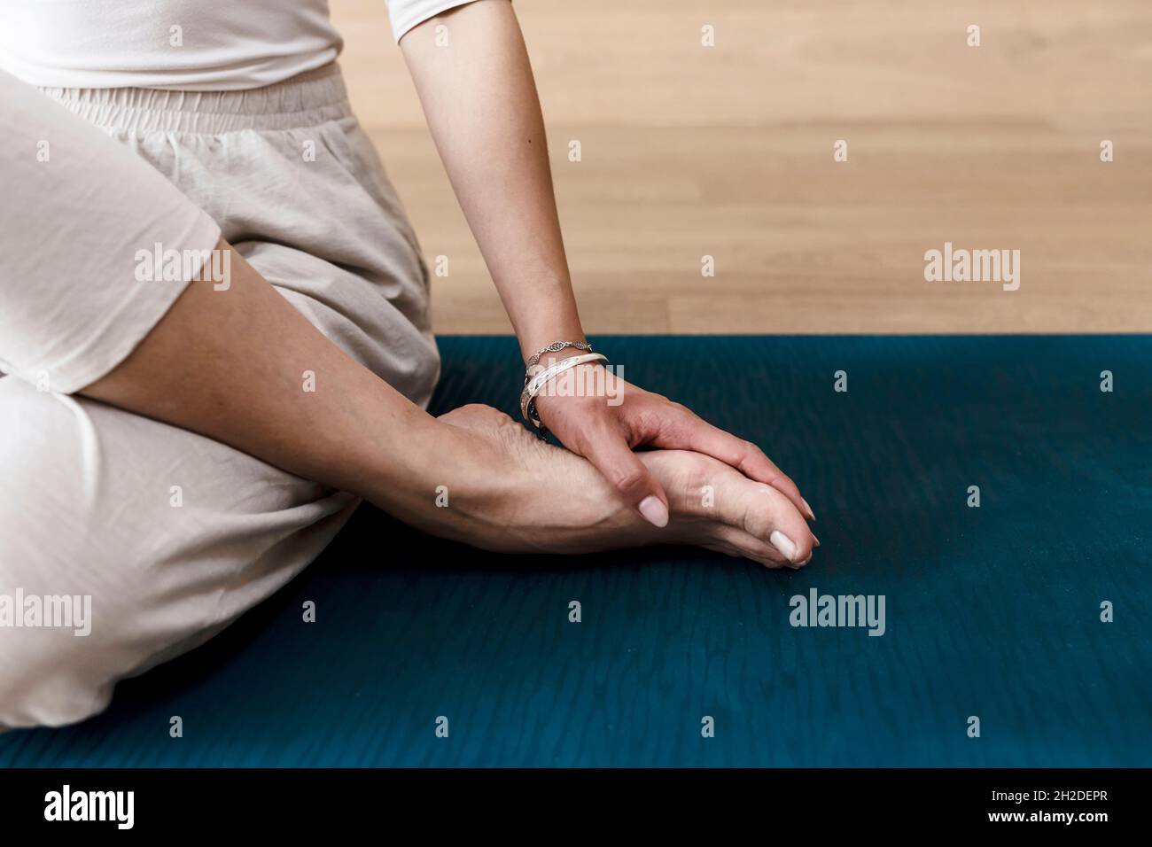 Asiatische Frau praktiziert Yoga Gomukhasana oder Kuh Gesicht Pose zur Meditation Stockfoto