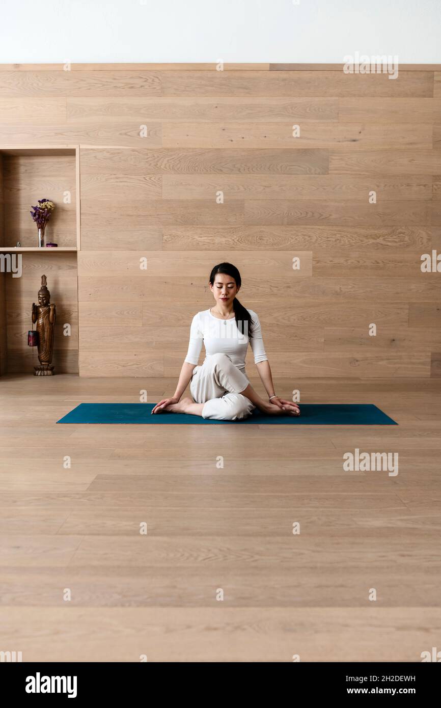 Asiatische Frau praktiziert Yoga Gomukhasana oder Kuh Gesicht Pose zur Meditation Stockfoto