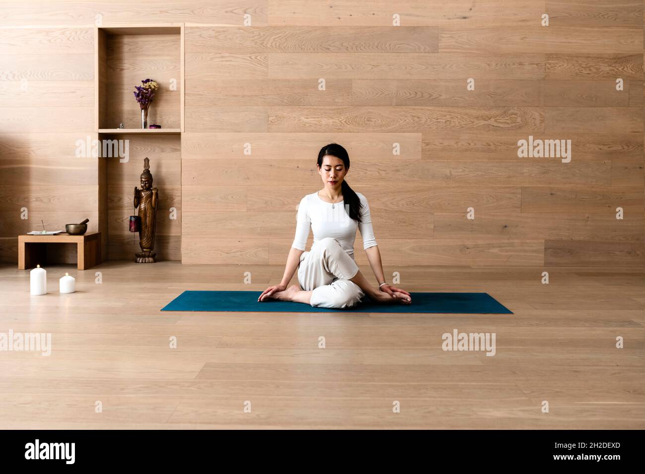 Asiatische Frau praktiziert Yoga Gomukhasana oder Kuh Gesicht Pose zur Meditation Stockfoto