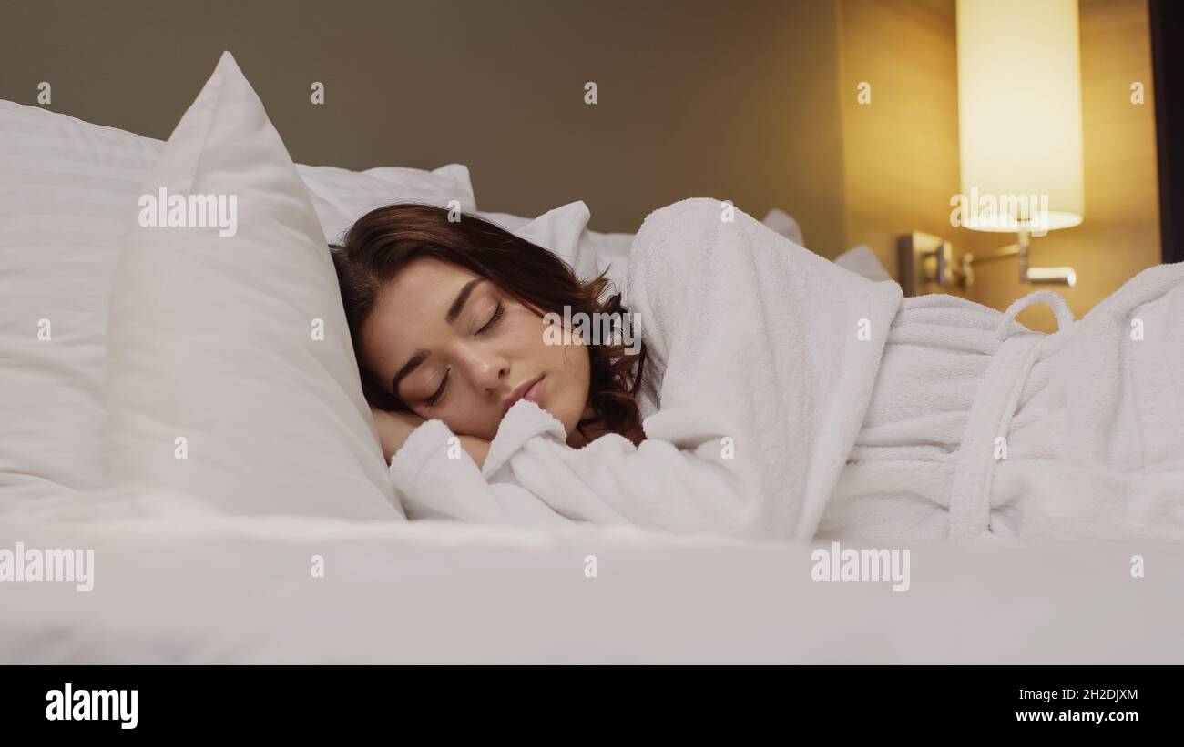 Oberflächennahe Ansicht einer jungen Frau, die im Hotelbett schläft Stockfoto