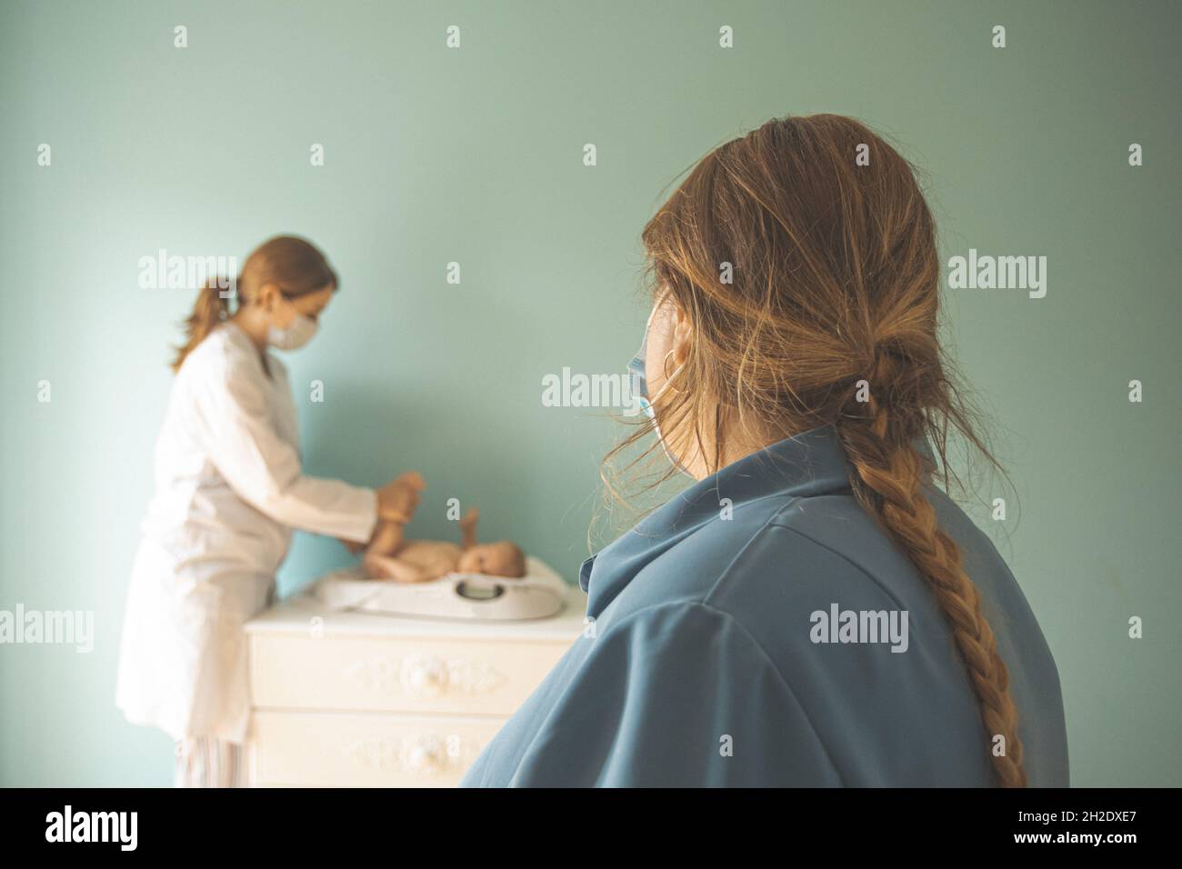 Baby auf Waage beim Arzt Stockfoto