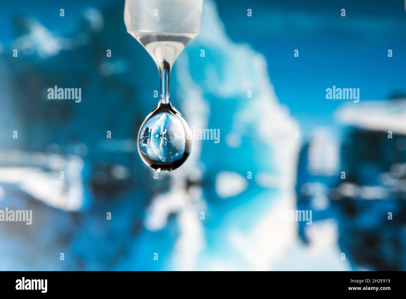 Brechung einer polaren Landschaft mit Eisbergen in einem fallenden Wassertropfen Stockfoto