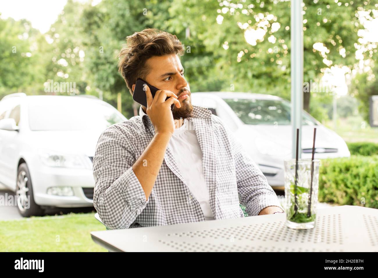 Selbstbewusster junger Mann, der im Freien telefoniert Stockfoto