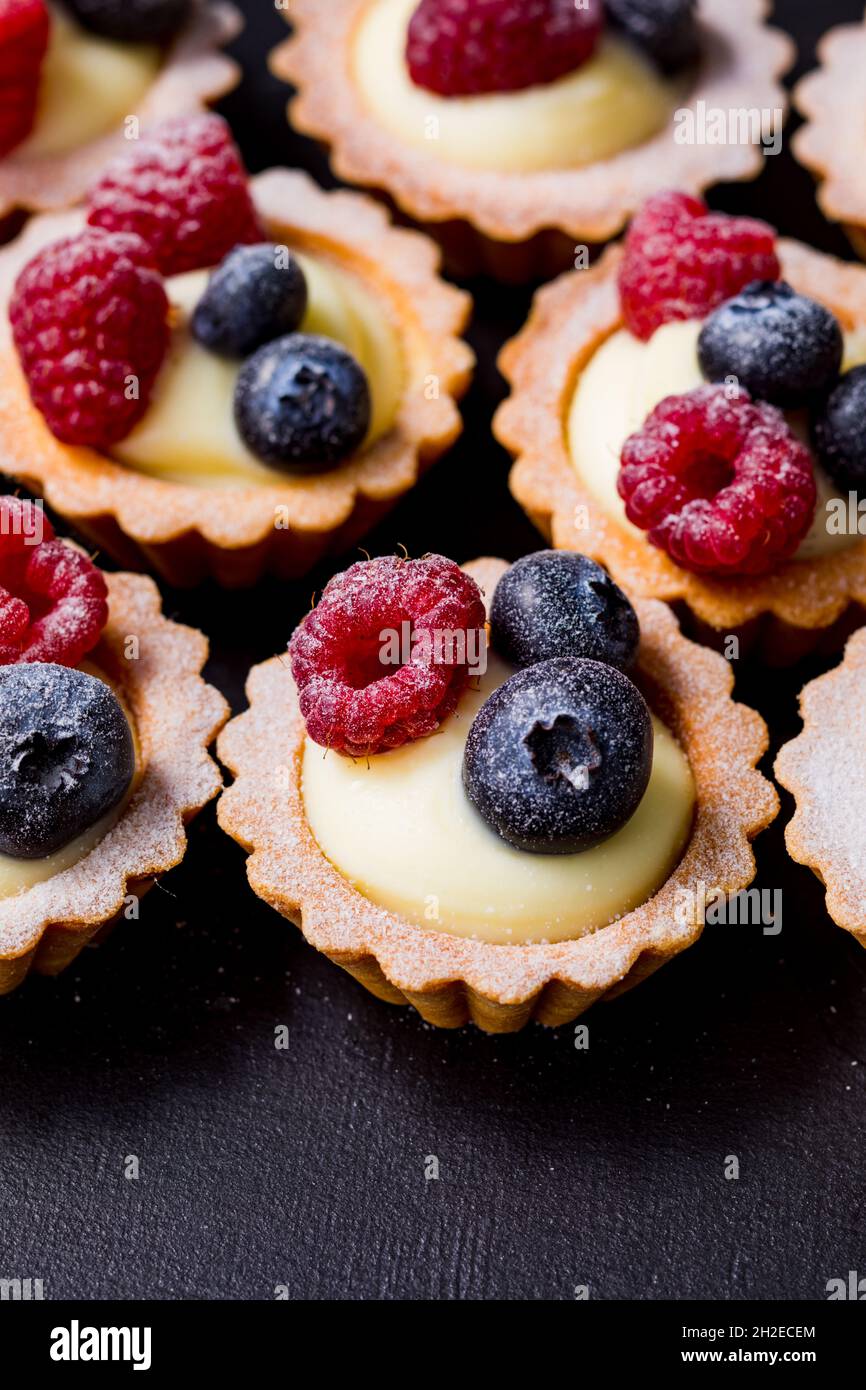 Nahaufnahme köstlicher Heidelbeer-Tartalets mit Vanillecreme Stockfoto