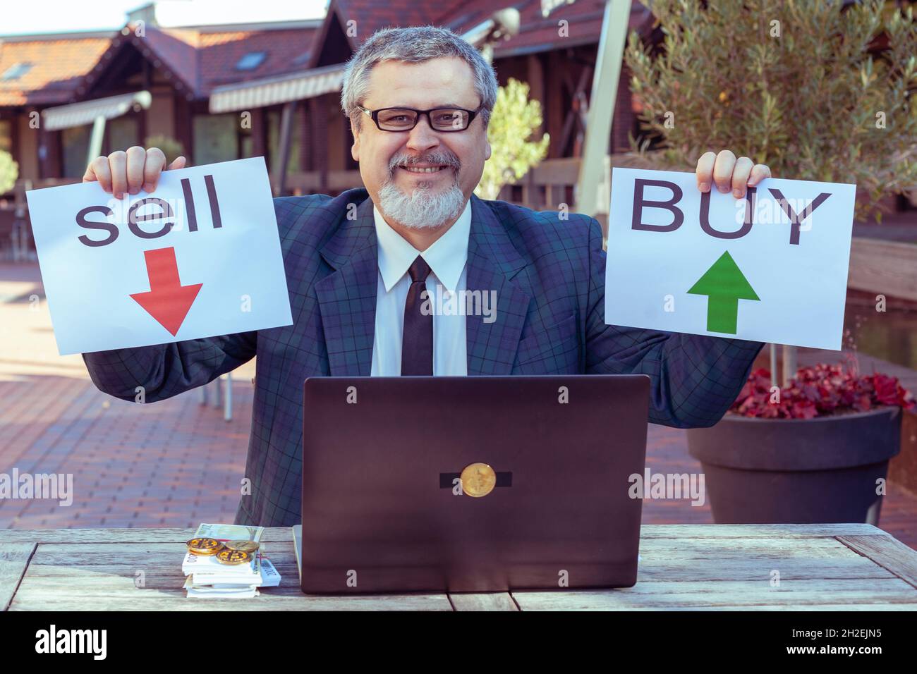 Man empfiehlt, einen Deal beim Kauf oder Verkauf zu machen. Er arbeitet an der Börse mit einem Laptop. Stockfoto