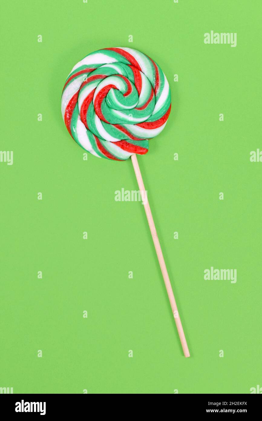Lollipop mit Weihnachtsfarben auf grünem Hintergrund Stockfoto