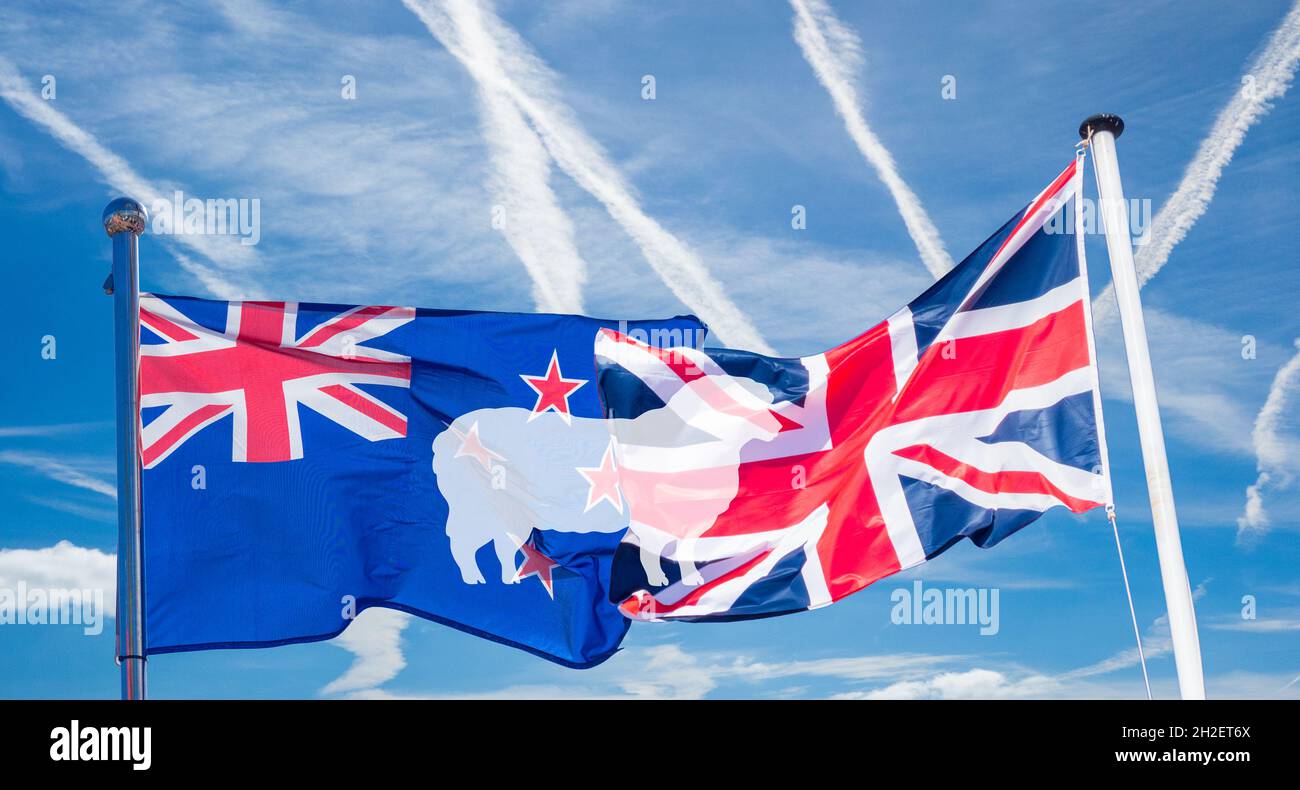 Flagge von Neuseeland und Großbritannien mit überlagerten Schafbildern. Handelsabkommen, billige Lammimporte... Konzept. Stockfoto