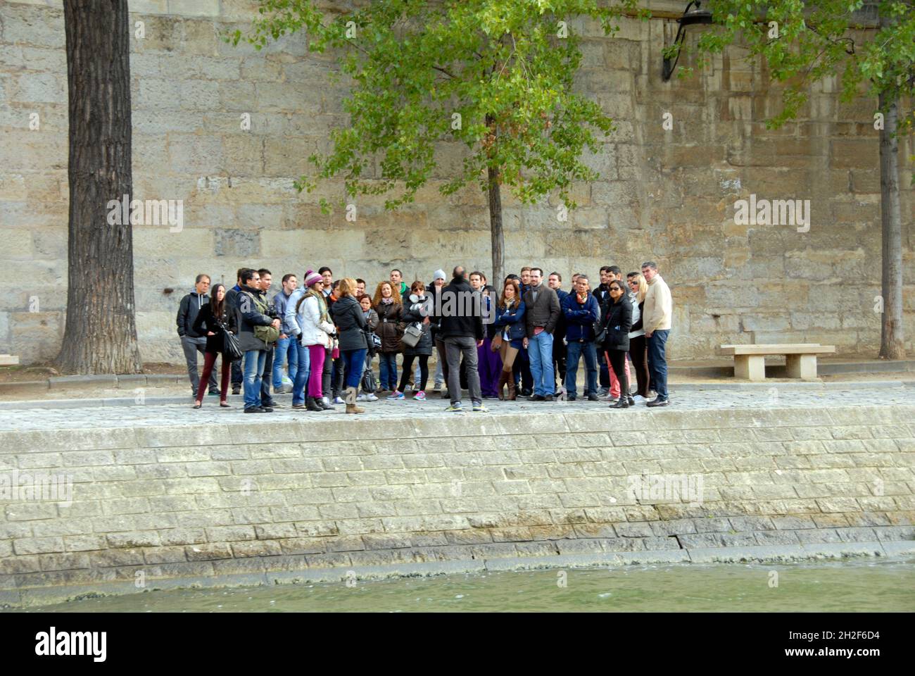 Eine große Gruppe von Personen auf einer geführten Tour, die vom Reiseleiter an der seine, Paris, Frankreich, angesprochen wird Stockfoto
