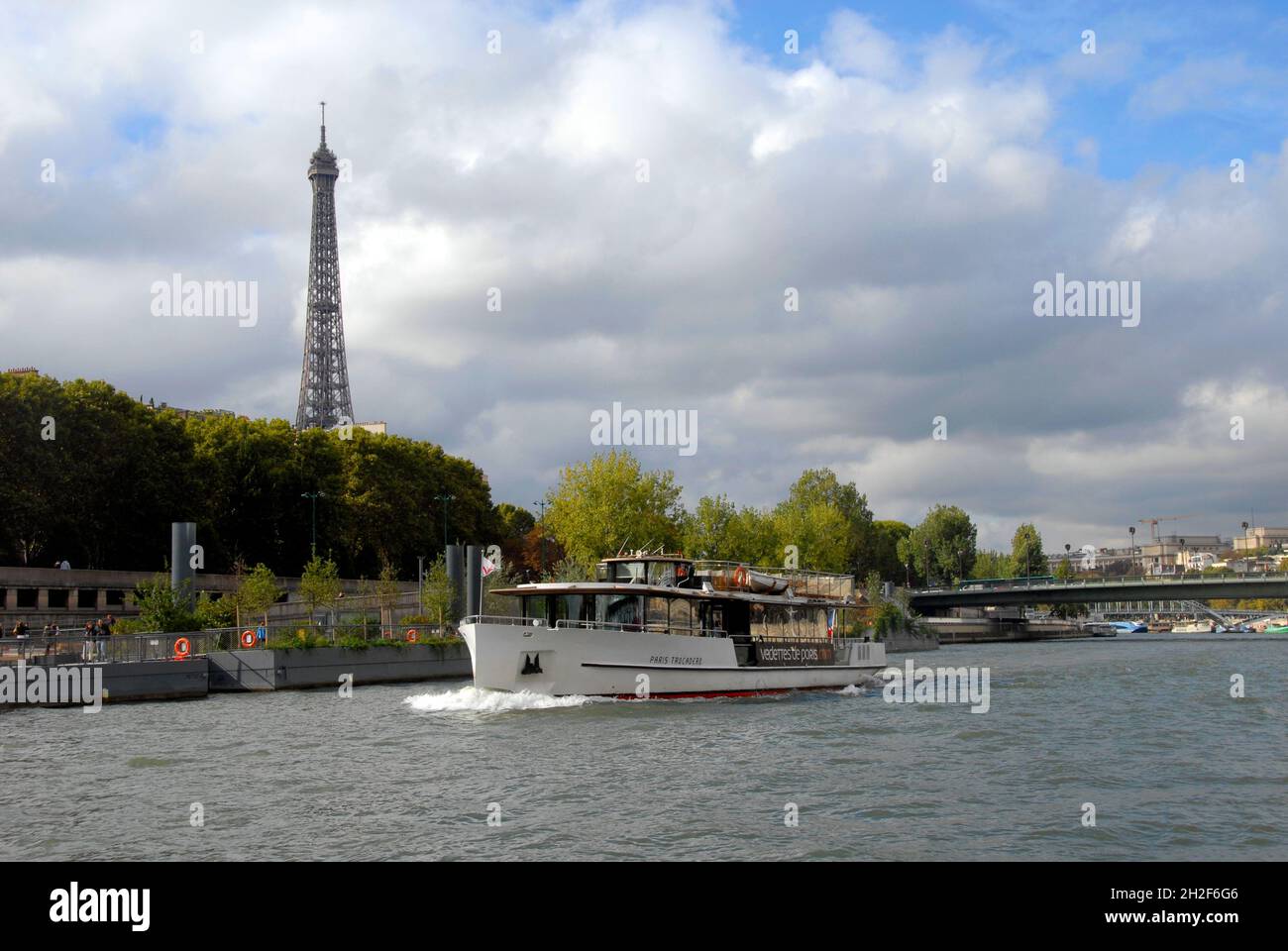 Vergnügungskreuzfahrtschiff auf der seine, Paris, Frankreich mit Eiffelturm dahinter Stockfoto Vergnügungskreuzfahrtschiff auf der seine, Paris, Frankreich mit Eiffelturm dahinter Stockfoto