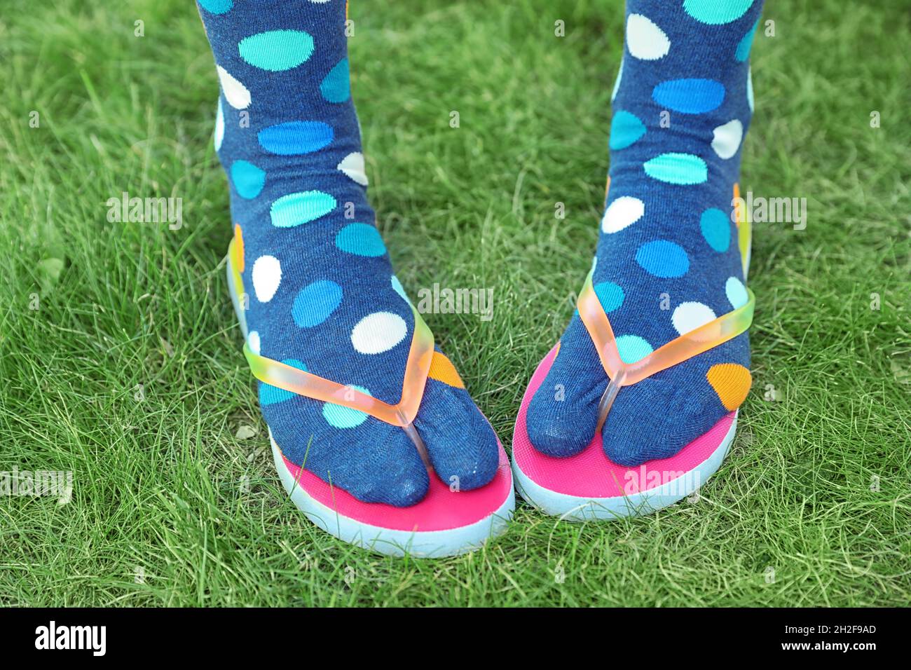 Frau trägt helle Socken mit Flip-Flops, die auf dem Boden stehen  Stockfotografie - Alamy