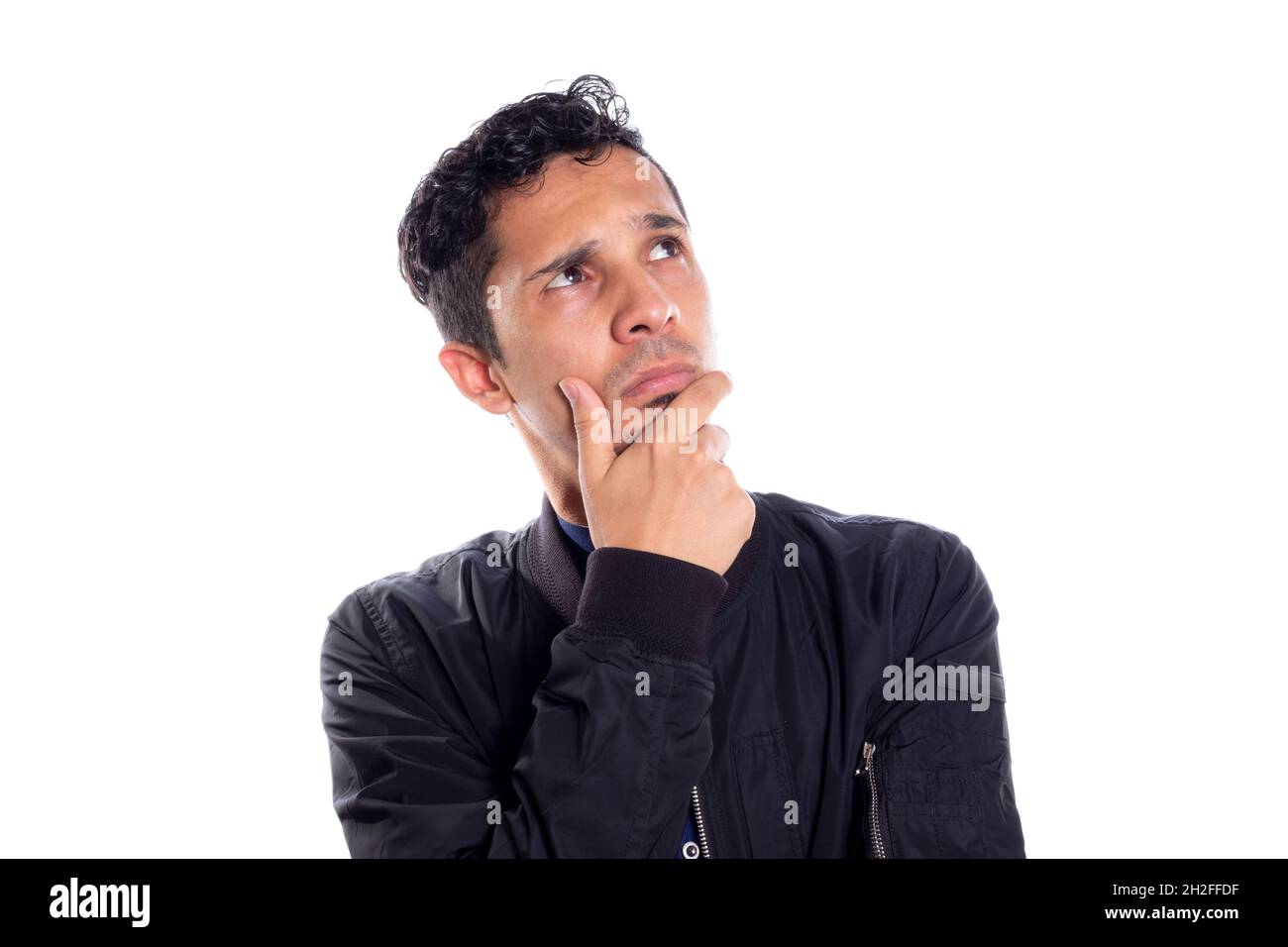 Nachdenklicher Mann mit der Hand auf dem Kinn. Weißer Hintergrund. Intelligenter Mann nachdenklich auf weißem Hintergrund. Junger erwachsener Latino junger Mann. Stockfoto