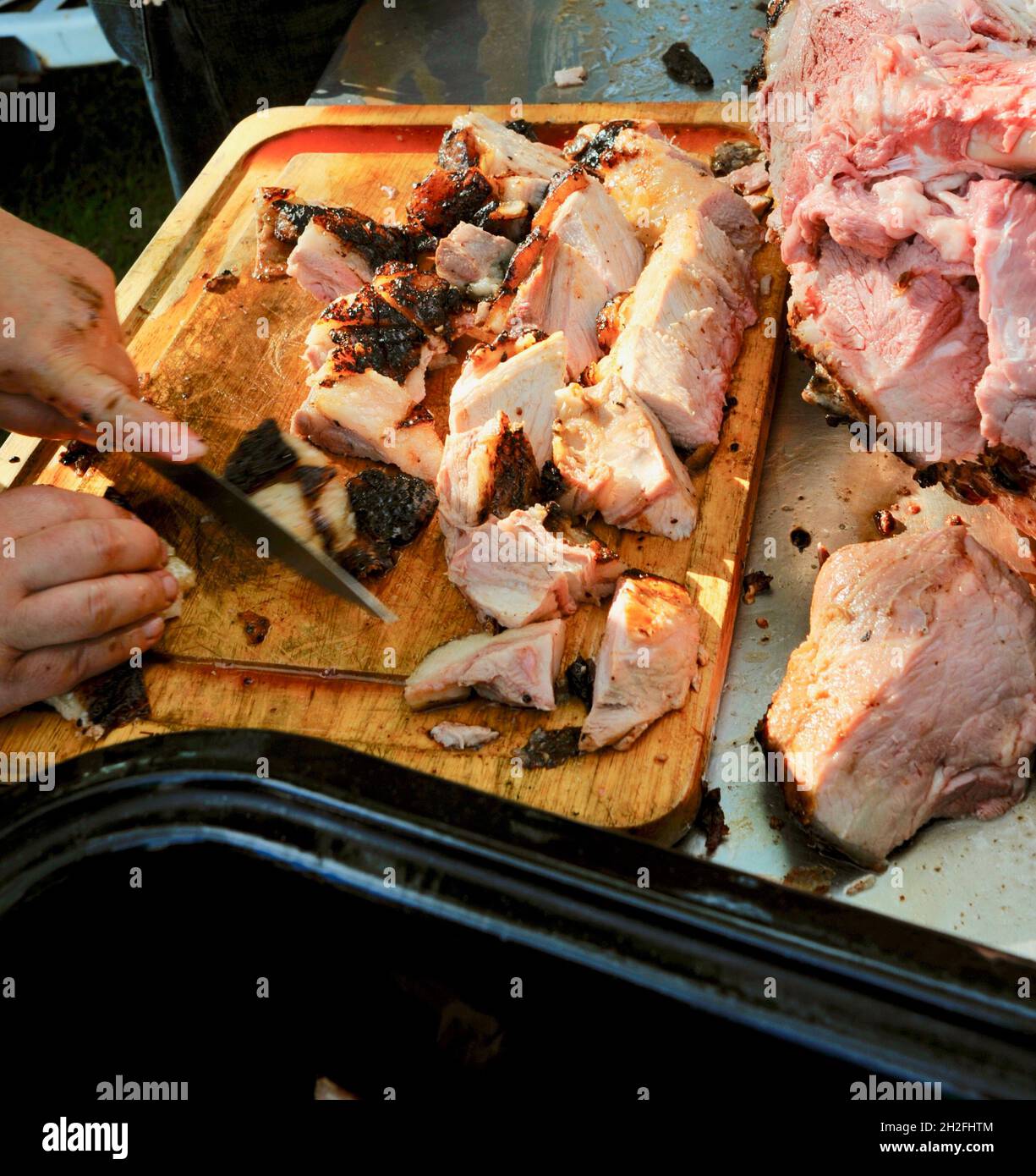 Schneiden und Schnitzen von Spieß-gebratenem Vollschwein auf einer Farm im Mittleren Westen, Blanchardville, Wisconsin, USA Stockfoto