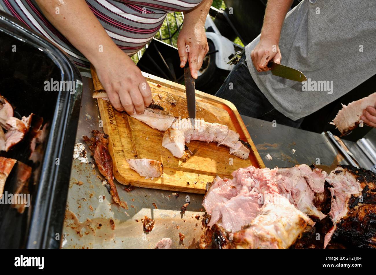 Schneiden und Schnitzen von Spieß-gebratenem Vollschwein auf einer Farm im Mittleren Westen, Blanchardville, Wisconsin, USA Stockfoto