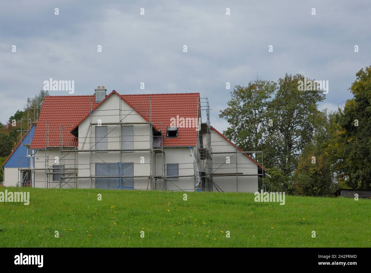 Hausbau.Gerüste Nahaufnahme. Neues Haus mit Dach in Gerüsten.Baumaterialien und der Prozess des Bauens Stockfoto