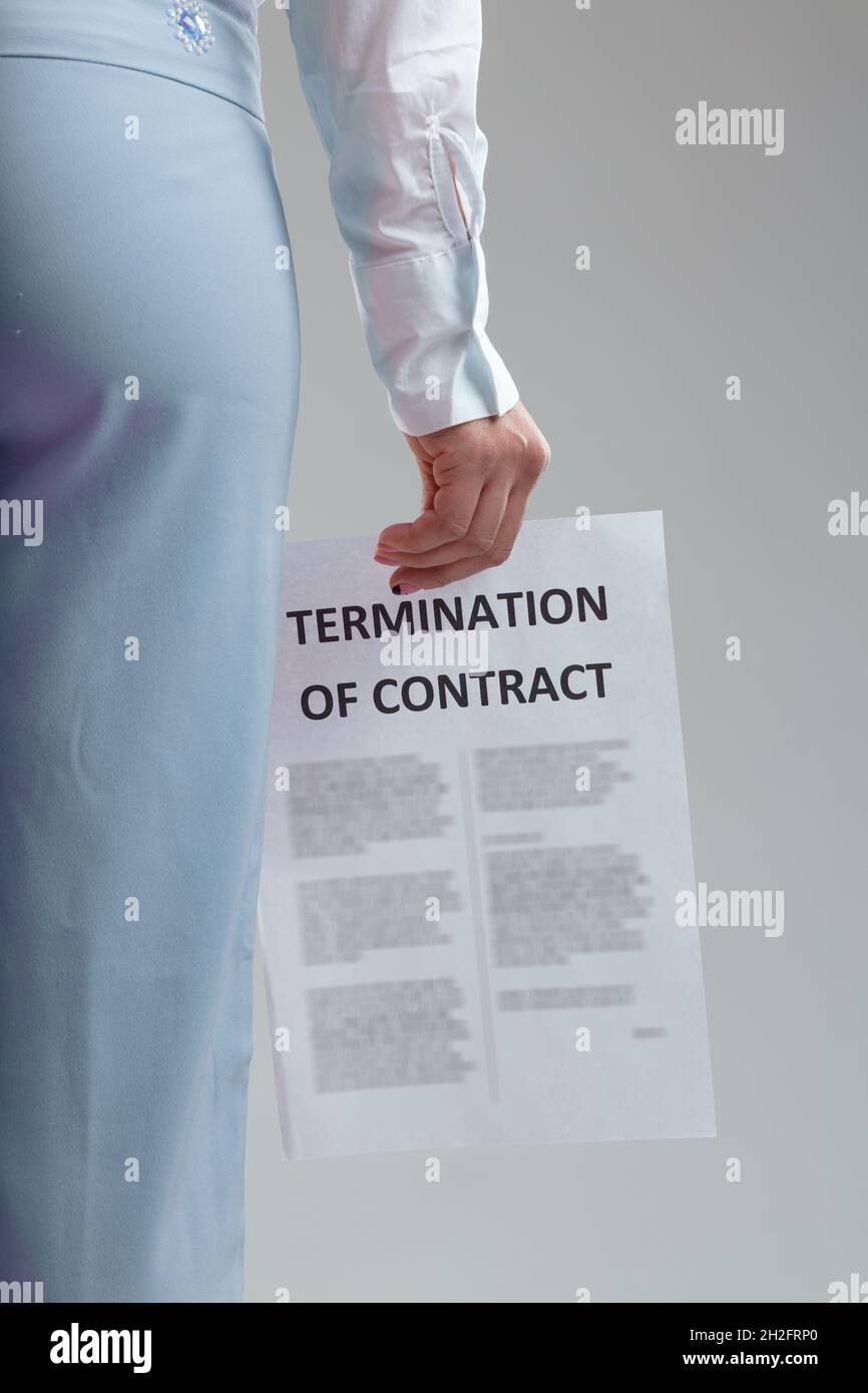 Rückansicht einer Geschäftsfrau, die eine Vertragsbeendigung in der Hand in einer Nahaufnahme des Rücktrittsdokuments in einem Beschäftigungskonzept trägt Stockfoto