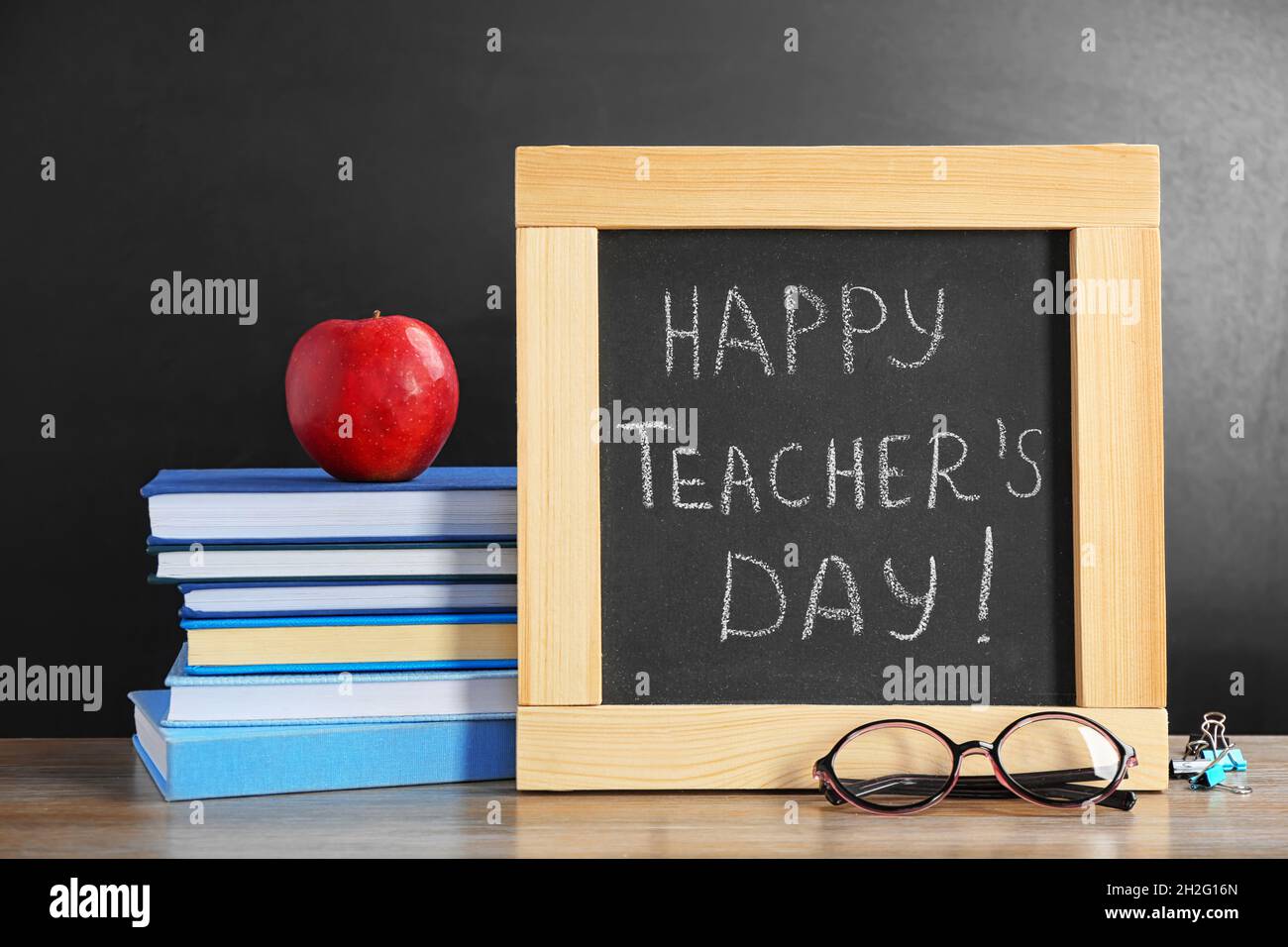 Kleine Tafel mit Aufschrift HAPPY TEACHER's DAY, Notizbücher und Brillen  auf dem Tisch Stockfotografie - Alamy