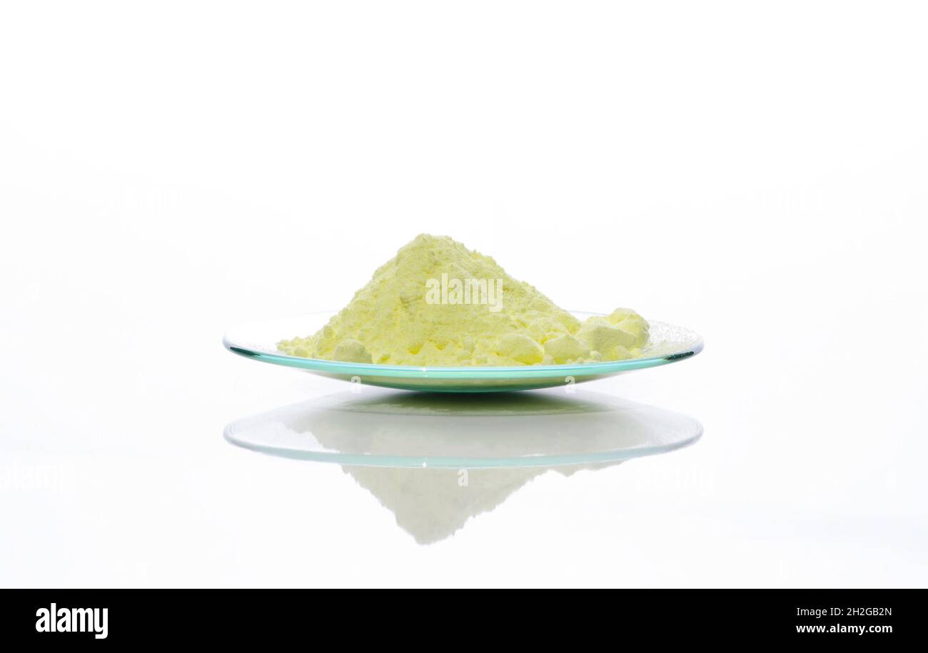 Schwefelpulver in chemischem Uhrenglas. Nahaufnahme des chemischen Inhaltsstoffs auf dem weißen Labortisch. Seitenansicht Stockfoto