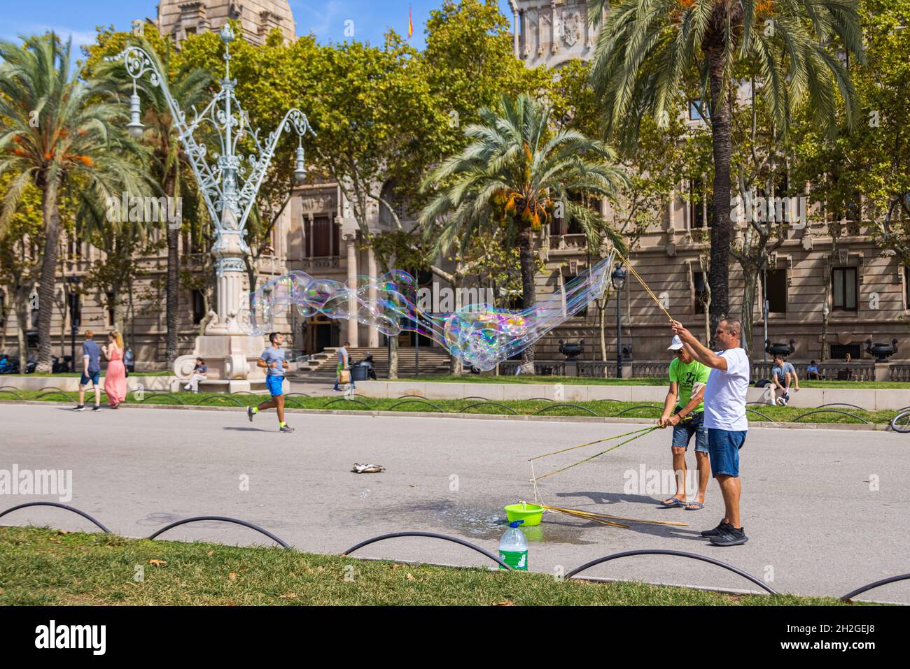 Barcelona, Spanien - 20. September 2021: Zwei Mann machen an einem Spätsommernachmittag auf den Straßen in der Nähe des Arc de Triomf riesige Seifenblasen. Touristen d Stockfoto