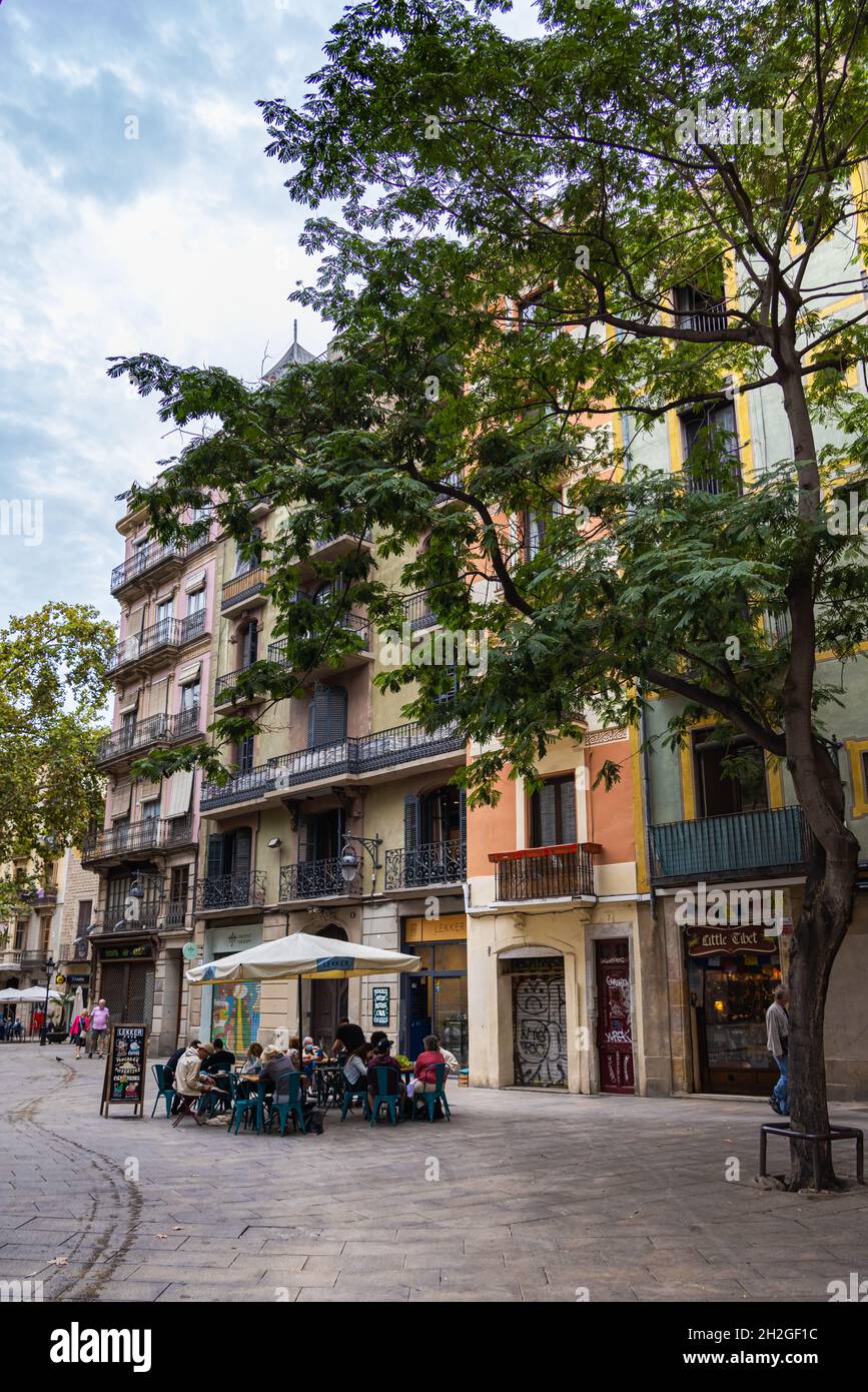 Barcelona, Spanien - 23. September 2021: Street Cafe in den Straßen von Barcelona. Menschen, die unter Sonnenschirmen sitzen und Kaffee oder Wein genießen. Stockfoto