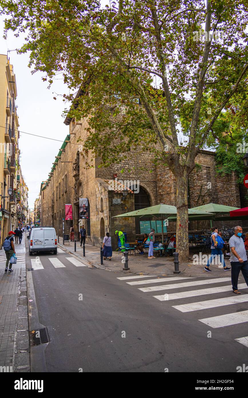 Barcelona, Spanien - 23. September 2021: Street Cafe in den engen Straßen von Barcelona. Menschen sitzen unter Sonnenschirmen und genießen Kaffee oder w Stockfoto