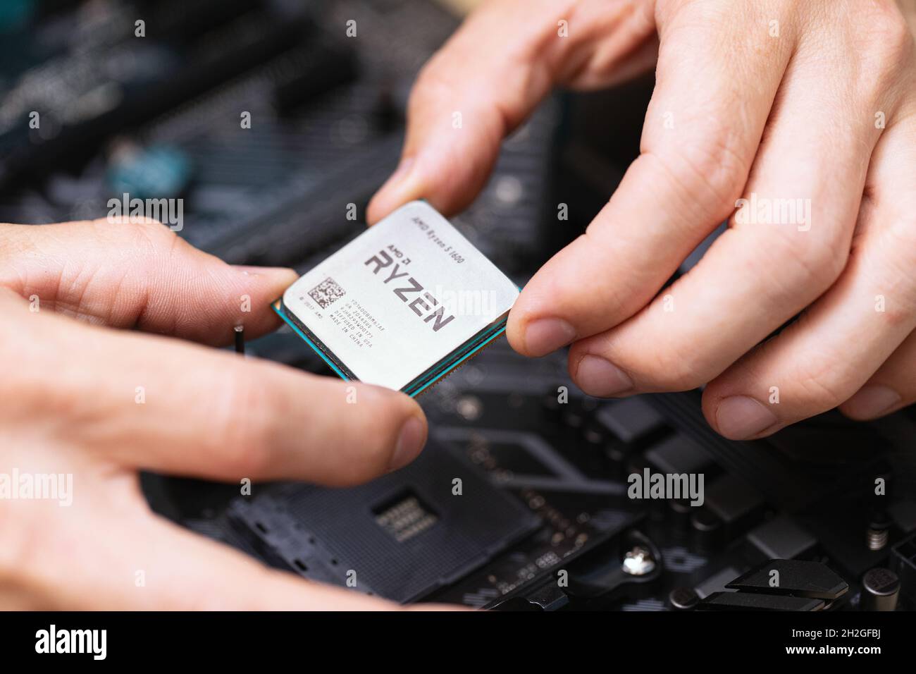 Nahaufnahme des Elektronikingenieurs, der Ryzan Mikroprozessor installiert. CPU-Hardware des Wartungscomputers. Hand halten Computer Prozessor-Chip. Konzept von c Stockfoto