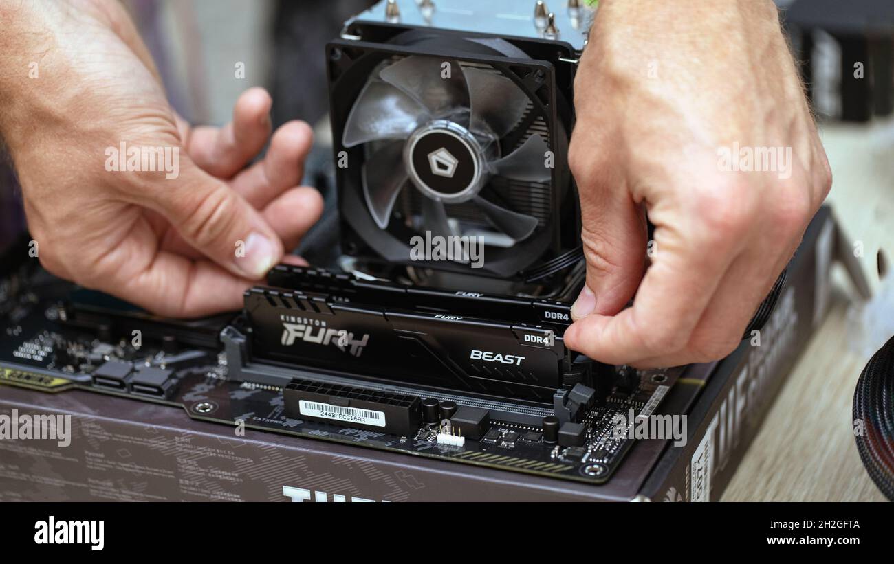 Nahaufnahme einer unbekannten Person, die Fury Beast RAM DDR4-Stick auf dem Mainboard eines professionellen Computers für Kryptowährungsbergbau installiert. Russland, 17.08.2021 Stockfoto