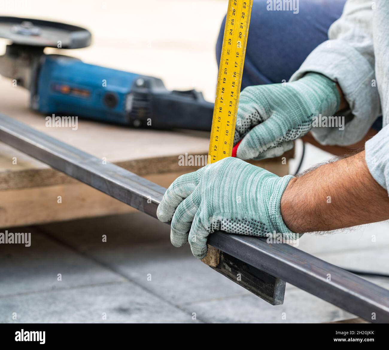 Mann misst Metall mit einem Lineal zum Schneiden, Hände aus nächster Nähe Stockfoto