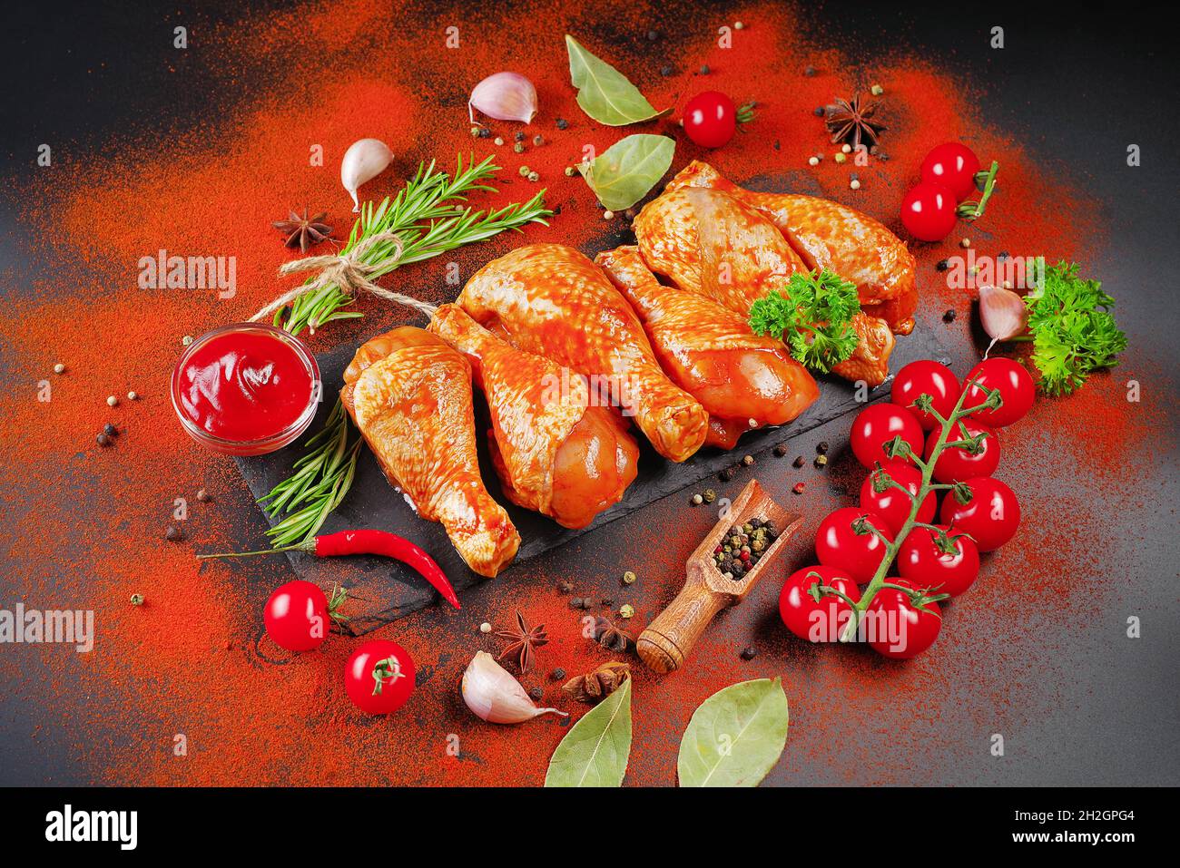 Convenience Food, vorgekocht.Roh mariniertes Hühnerfleisch Beine mit Gewürzen zum Kochen für BBQ dunklen Hintergrund. Draufsicht.Speicherplatz kopieren. Stockfoto