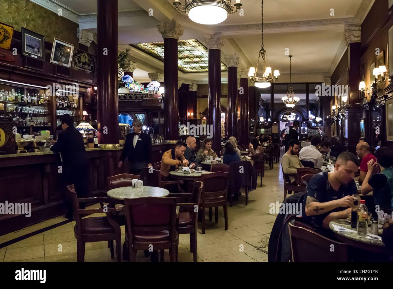 Horizontaler Blick auf das Retro-Interieur des Café Tortoni (das älteste Café der Stadt), voller Kunden, Microcentro, Buenos Aires, Argentinien Stockfoto